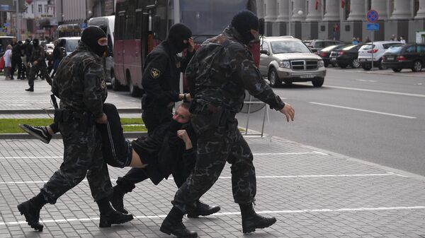 Сотрудники правоохранительных органов задерживают участника акции протеста в Минске