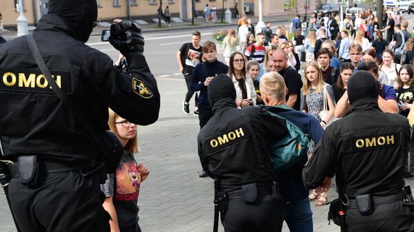 Сотрудники ОМОНа во время задержания участника акции в Минске 