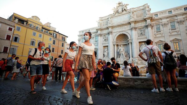 Люди в защитных масках около фонтана Треви в Риме 
