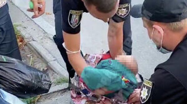 Стоп-кадр видео, где сотрудники полиции достают из сумки 2-х месячного ребенка в Киеве