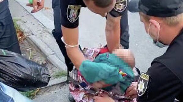 Стоп-кадр видео, где сотрудники полиции достают из сумки 2-х месячного ребенка в Киеве