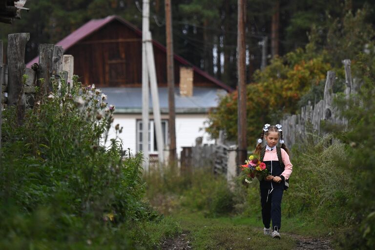 Ученица Юрт-Акбалыкской средней школы в Новосибирской области идет на праздничную линейку 1 сентября