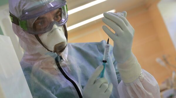 Медицинский сотрудник наполняет шприц в стационаре для больных с коронавирусной инфекцией