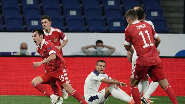 Защитник сборной России Вячеслав Караваев (на первом плане слева) радуется забитому мячу