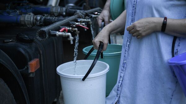 Жители Cимферополя набирают в емкости питьевую воду, привезенную в цистернах
