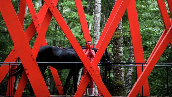 Конь и красный мальчик в спектакле Переходный период в Красном лесу — арт-объекте Игоря Шелковского на фестивале Архстояние. 