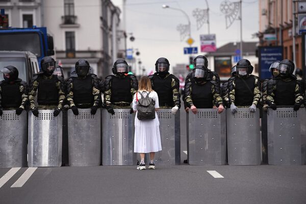 Участница несанкционированной акции оппозиции Марш единства и сотрудники милиции на улице в Минске