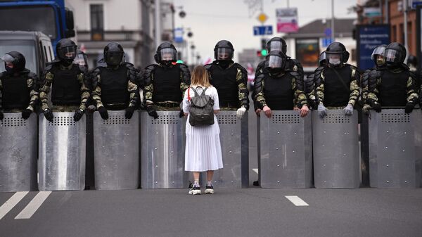 Участница несанкционированной акции оппозиции Марш единства и сотрудники милиции на улице в Минске