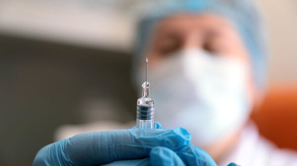Медик держит шприц с вакциной