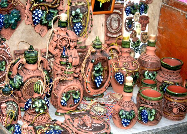 Декоративные глиняные чашки и кувшины, украшенные голубым виноградом в Молдавии
