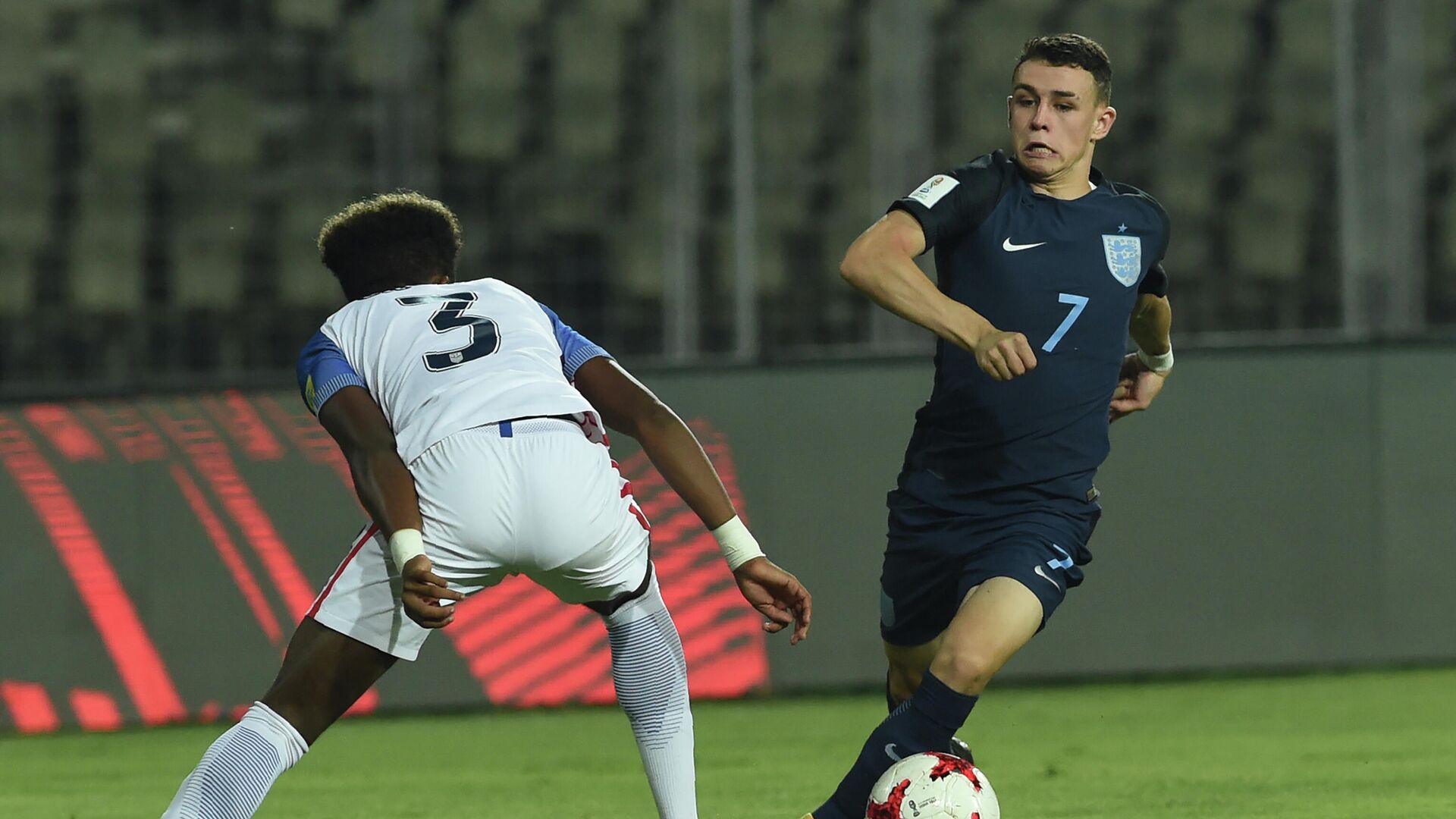 Philip Foden (R) of England dribbles past Chris Gloster of USA during the quarterfinal football match between USA and England in the FIFA U-17 World Cup at the Jawaharlal Nehru Stadium in Goa on October 21, 2017. (Photo by INDRANIL MUKHERJEE / AFP) - РИА Новости, 1920, 07.09.2020