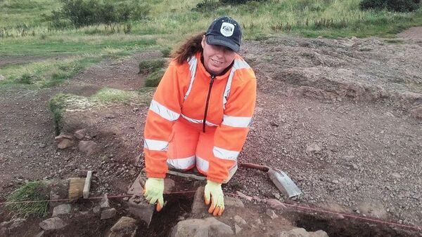 Археолог во время раскопок на горе Трон Артура в Шотландии