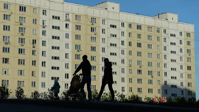 Семья на прогулке во дворе жилого дома