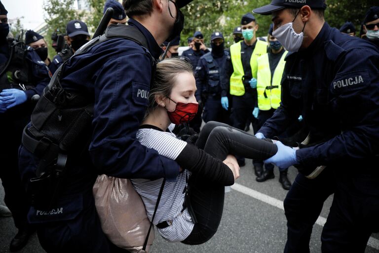 Сотрудники полиции задерживают участников акции протеста в Варшаве