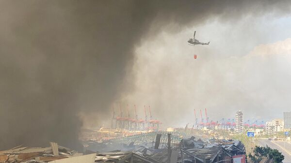 Вертолет во время тушения пожара на территории порта в Бейруте