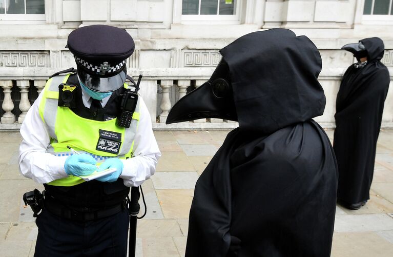 Полицейский с активистом Extinction Rebellion во время акции протеста в Лондоне, Великобритания