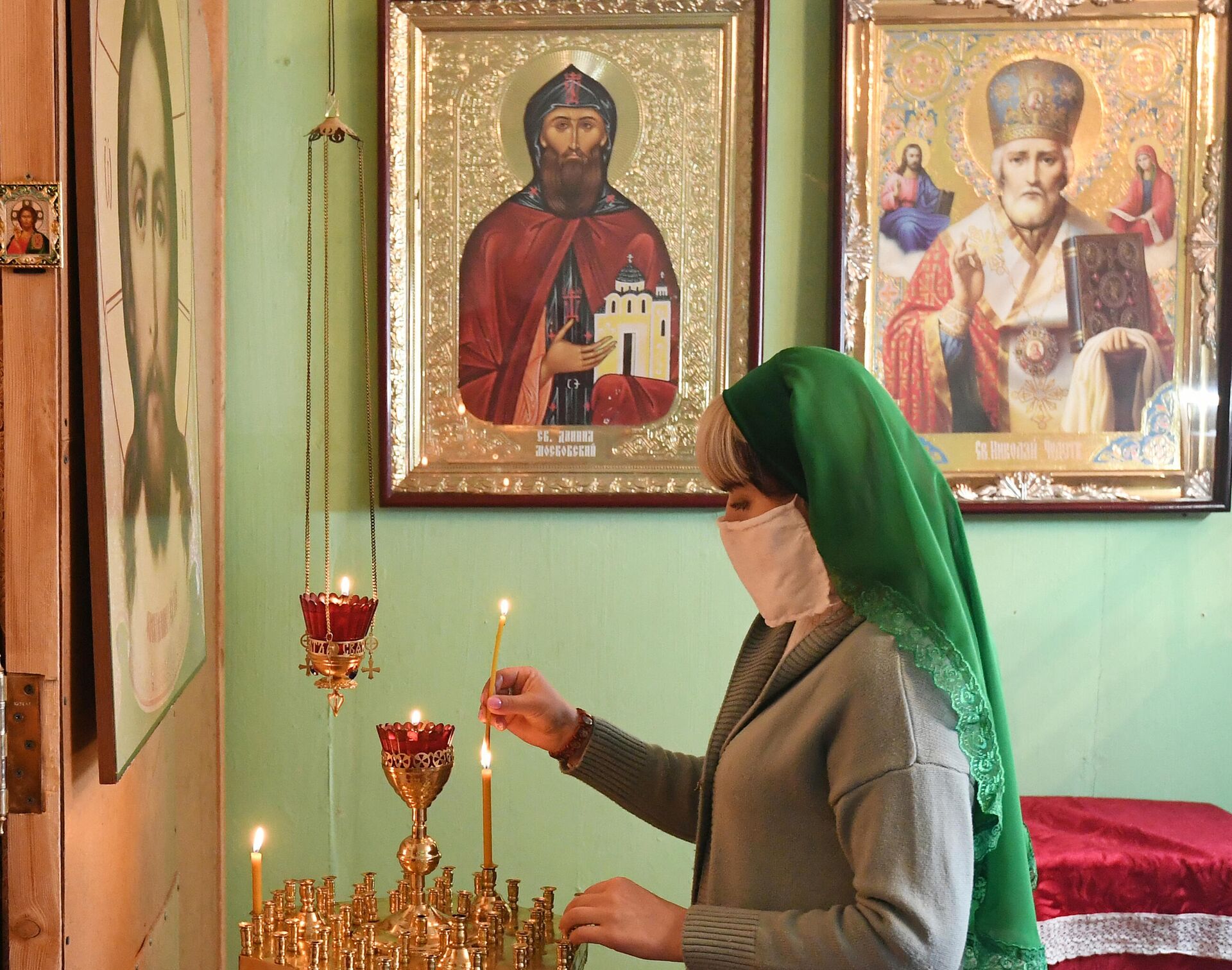 Верующая в медицинской маске во время Божественной литургии в день Лазаревой субботы в православном Храме Святаго Князя Даниила Московского в селе Бартат Красноярского кра - РИА Новости, 1920, 28.10.2020