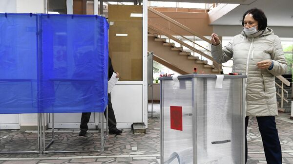 Женщина голосует на выборах губернатора Иркутской области на избирательном участке в Иркутске