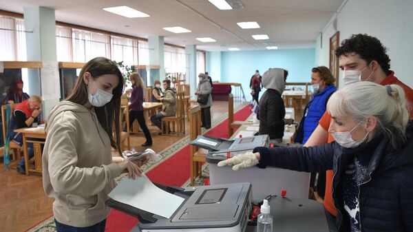 Девушка голосует на избирательном участке в Архангельской области