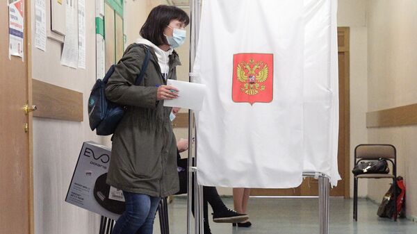 Девушка голосует на избирательном участке во время выборов губернатора Ленинградской области
