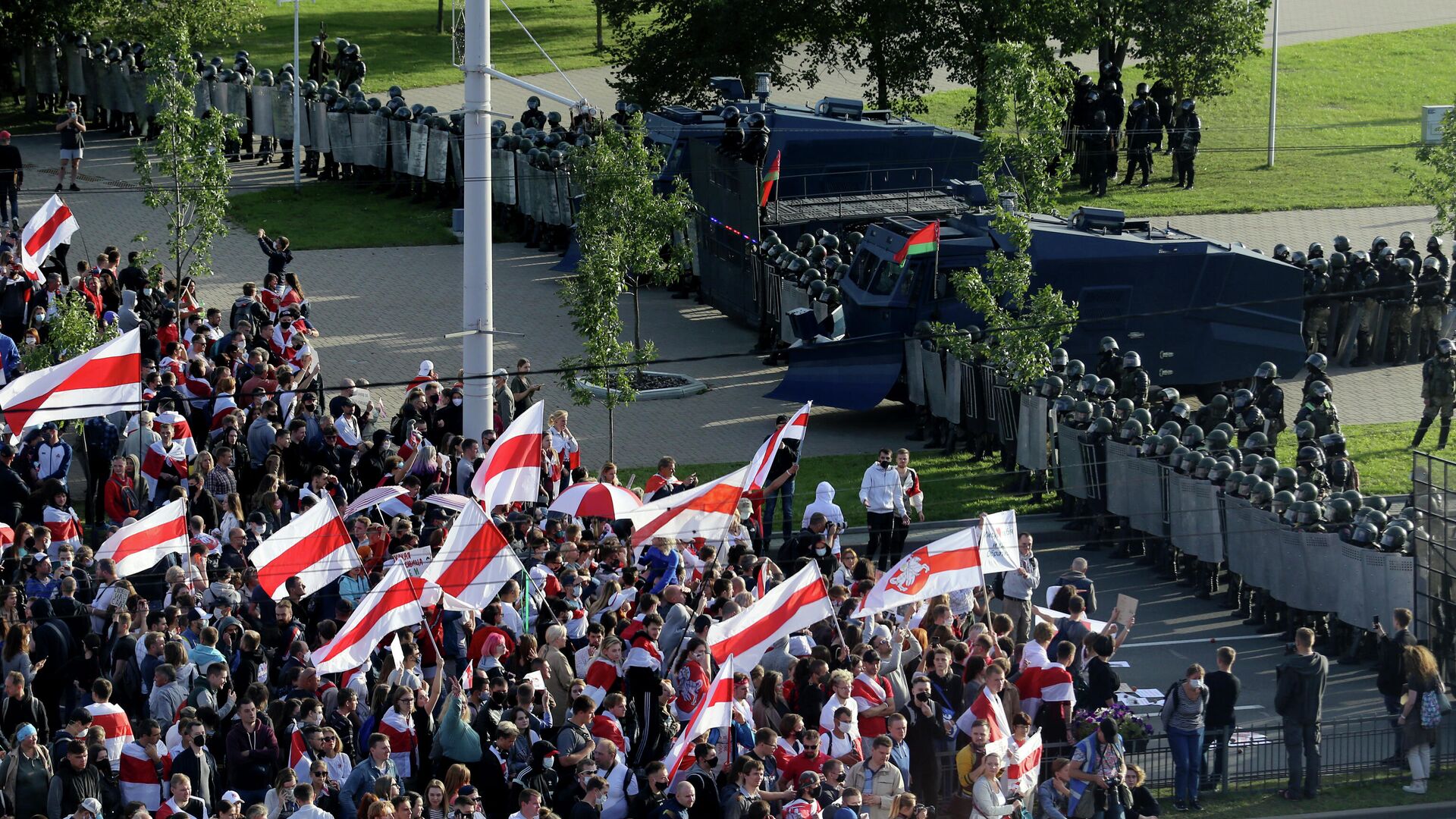 Участники оппозиционного митинга перед сотрудниками правоохранительных органов, перекрывающими улицу, во время протеста против результатов президентских выборов в Минске - РИА Новости, 1920, 14.09.2020