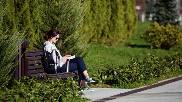 Девушка читает книгу на набережной
