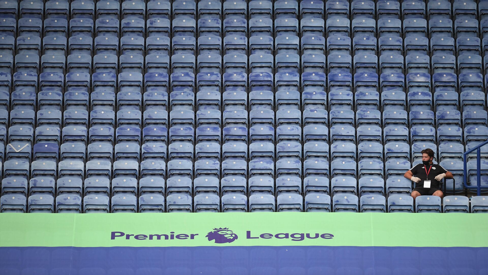 A member of staff sits in the empty stands during the English Premier League football match between Leicester City and Manchester United at King Power Stadium in Leicester, central England on July 26, 2020. (Photo by Oli SCARFF / POOL / AFP) / RESTRICTED TO EDITORIAL USE. No use with unauthorized audio, video, data, fixture lists, club/league logos or 'live' services. Online in-match use limited to 120 images. An additional 40 images may be used in extra time. No video emulation. Social media in-match use limited to 120 images. An additional 40 images may be used in extra time. No use in betting publications, games or single club/league/player publications. /  - РИА Новости, 1920, 16.09.2020