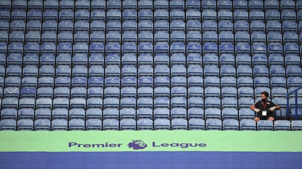 A member of staff sits in the empty stands during the English Premier League football match between Leicester City and Manchester United at King Power Stadium in Leicester, central England on July 26, 2020. (Photo by Oli SCARFF / POOL / AFP) / RESTRICTED TO EDITORIAL USE. No use with unauthorized audio, video, data, fixture lists, club/league logos or 'live' services. Online in-match use limited to 120 images. An additional 40 images may be used in extra time. No video emulation. Social media in-match use limited to 120 images. An additional 40 images may be used in extra time. No use in betting publications, games or single club/league/player publications. / 
