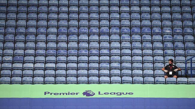 A member of staff sits in the empty stands during the English Premier League football match between Leicester City and Manchester United at King Power Stadium in Leicester, central England on July 26, 2020. (Photo by Oli SCARFF / POOL / AFP) / RESTRICTED TO EDITORIAL USE. No use with unauthorized audio, video, data, fixture lists, club/league logos or 'live' services. Online in-match use limited to 120 images. An additional 40 images may be used in extra time. No video emulation. Social media in-match use limited to 120 images. An additional 40 images may be used in extra time. No use in betting publications, games or single club/league/player publications. / 