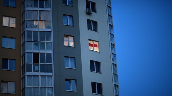 Неофициальный флаг Белоруссии в окне жилого дома на улице Червякова в Минске