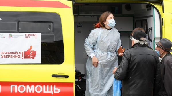 Жители Казани у машины скорой помощи, где проходит бесплатная вакцинация от гриппа