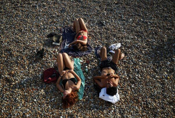Люди загорают на пляже в Брайтоне, Великобритания