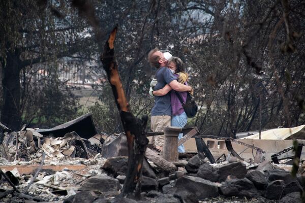 Молодые люди на месте разрушенного дома после пожара в Альмеде, штат Орегон
