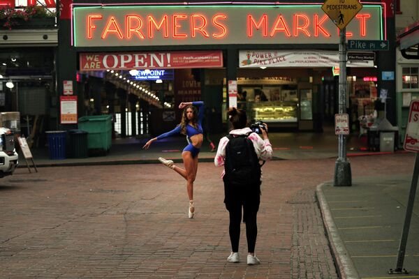 Танцовщица позирует фотографу на рынке Пайк-плейс в Сиэтле, штат Вашингтон, США