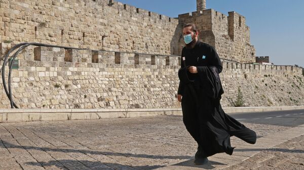 Священнослужитель в защитной маске в Старом городе Иерусалима