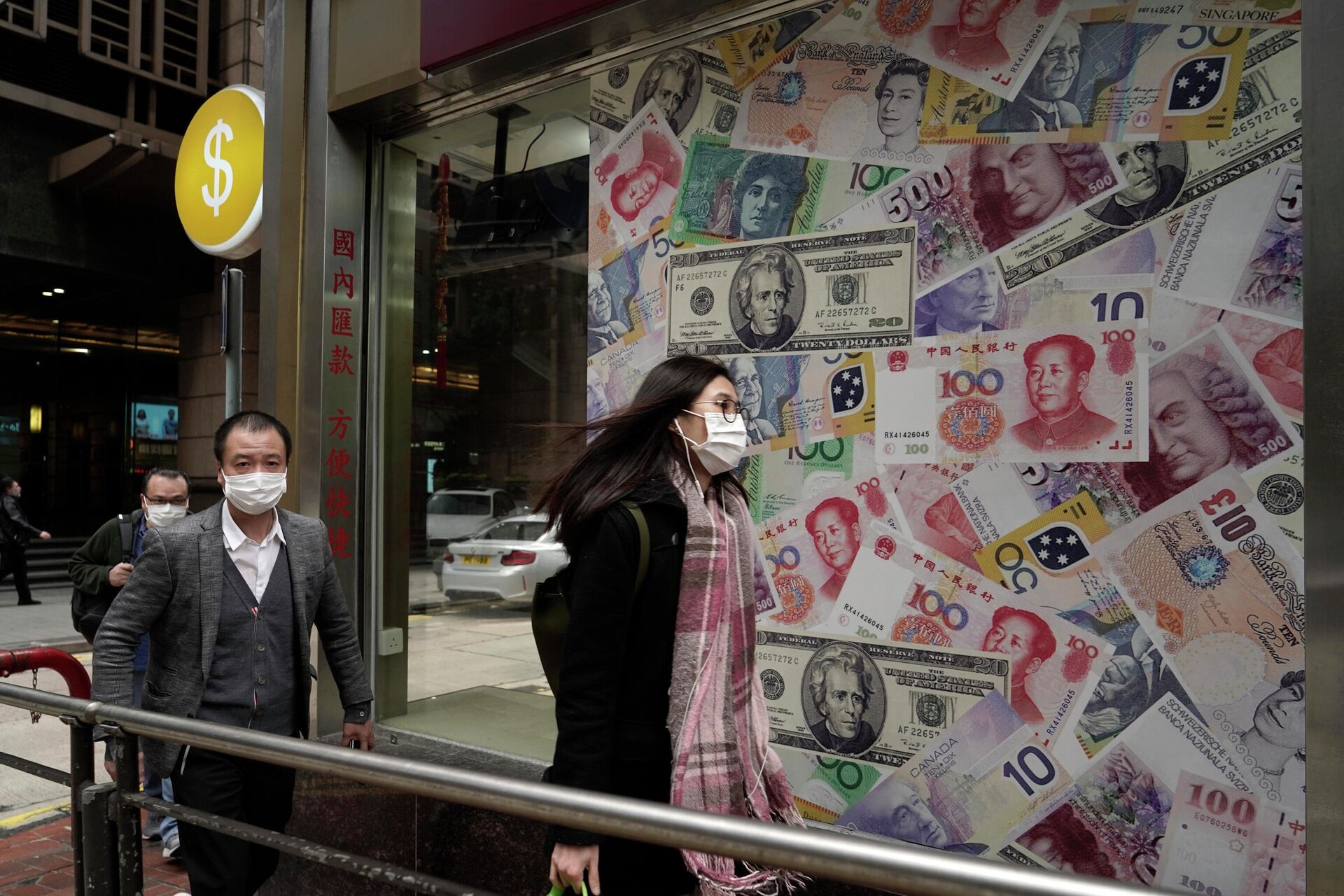 Люди в защитных масках проходят мимо пункта обмена валют в Гонконге - РИА Новости, 1920, 29.03.2022