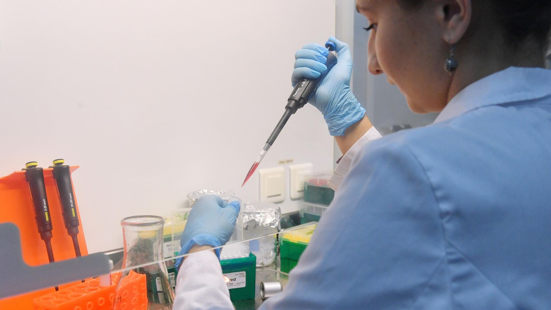 Сотрудница лаборатории проводит испытания вакцины от COVID-19 - РИА Новости, 1920, 09.09.2021
