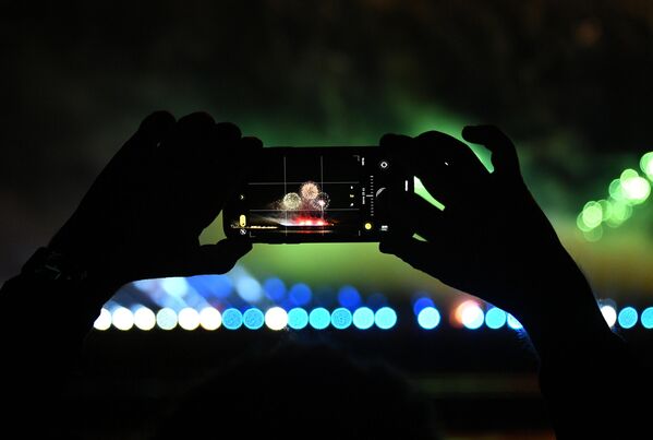Зритель фотографирует салют на международном фестивале фейерверков Ростех, который проходит на территории парка Патриот