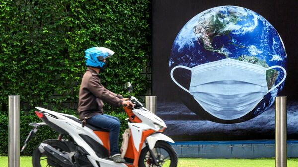 Мужчина на скутере у плаката в Бангкоке