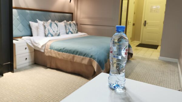 Бутылка воды на столике в номере 239 гостиницы Xander Hotel в Томске
