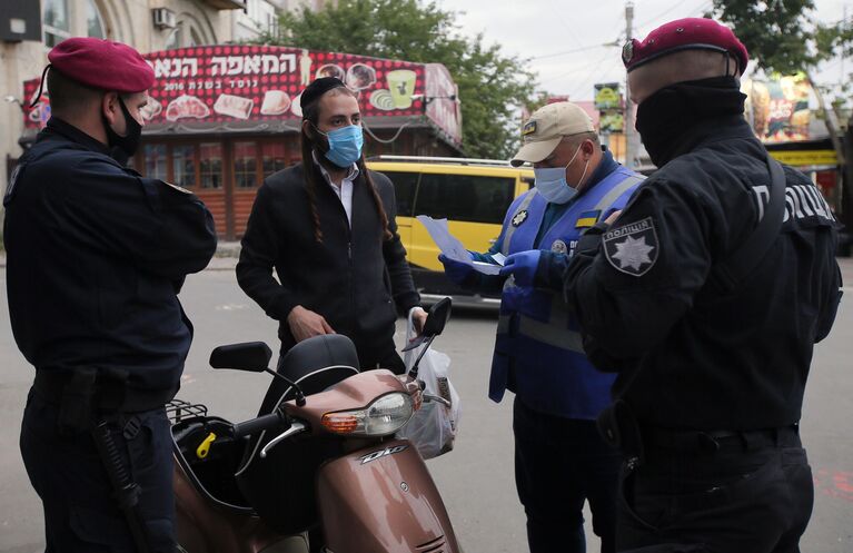 Сотрудники полиции города Умани проверяют документы паломника-хасида, прибывшего в город на празднование иудейского Нового года (Рош ха-Шана)