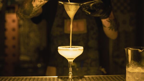 Бармен наливает коктейль в одном из баров Афин