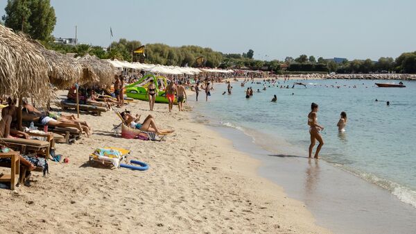 Туристы на пляже в пригороде Афин