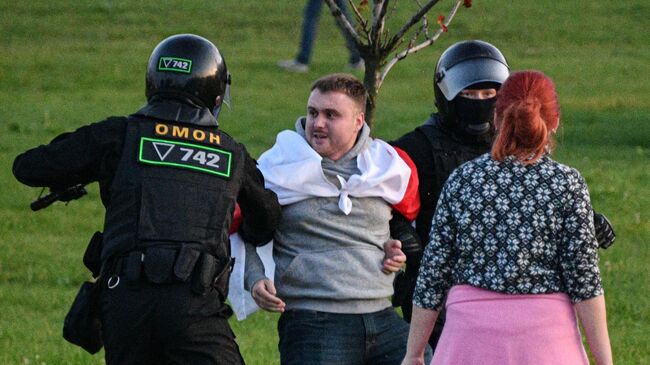 Сотрудники милиции задерживают участника акции протеста в Минске