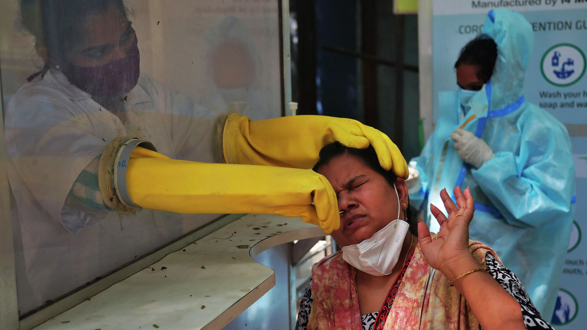 Медицинский работник берет мазок из носа для тестирования на COVID-19 в Хайдарабаде, Индия - РИА Новости, 1920, 02.10.2020