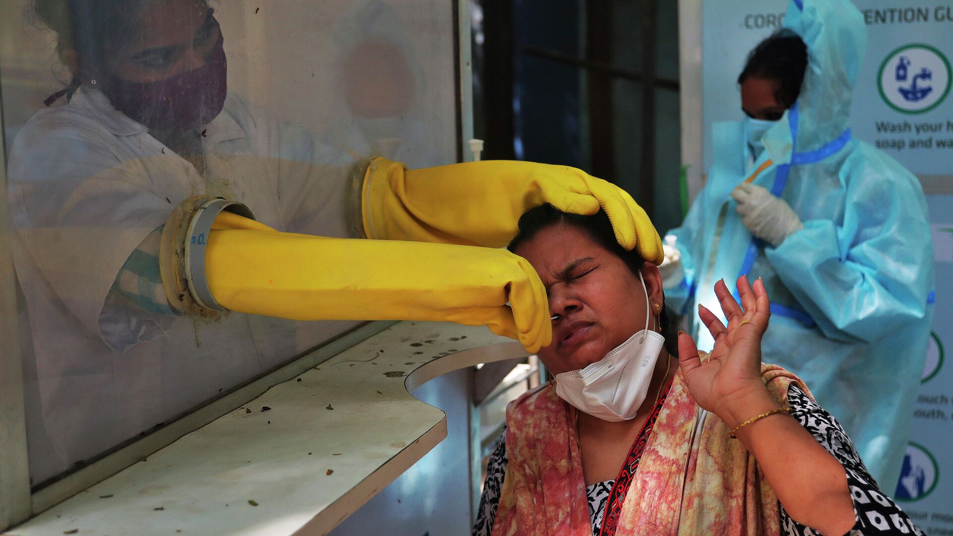 Медицинский работник берет мазок из носа для тестирования на COVID-19 в Хайдарабаде, Индия - РИА Новости, 1920, 12.11.2020