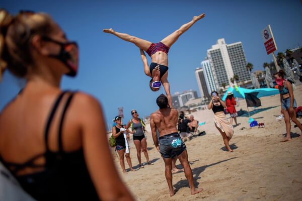 Акробаты во время акции протеста против решения правительства закрыть пляжи из-за пандемии коронавируса в Тель-Авиве