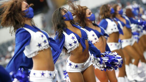Девушки из группы поддержки Dallas Cowboys выступают во время матча НФЛ в Арлингтоне, штат Техас