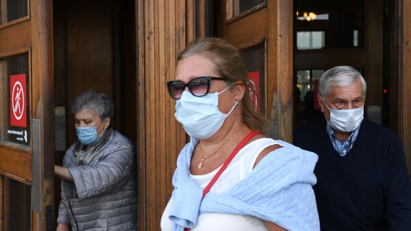 Пассажиры в медицинских масках выходят из вестибюля станции метро Парк культуры в Москве