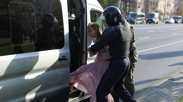 Сотрудники правоохранительных органов задерживают женщину во время митинга оппозиции в Минске